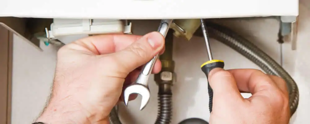 Boiler repair technician tightening pipe fittings and connections in Las Vegas, NV