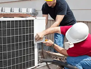 HVAC technicians repairing an outdoor AC unit on a rooftop in Las Vegas, NV