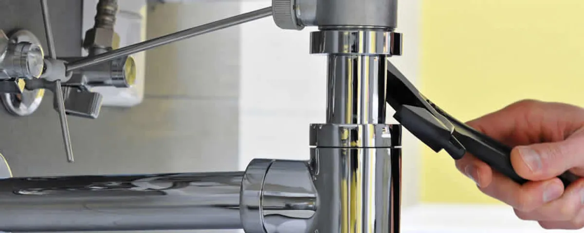 Plumber tightening a kitchen sink drain pipe connection in Las Vegas, NV