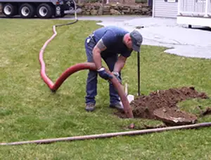 Septic pumping technician servicing a residential septic tank with a vacuum hose in Las Vegas, NV