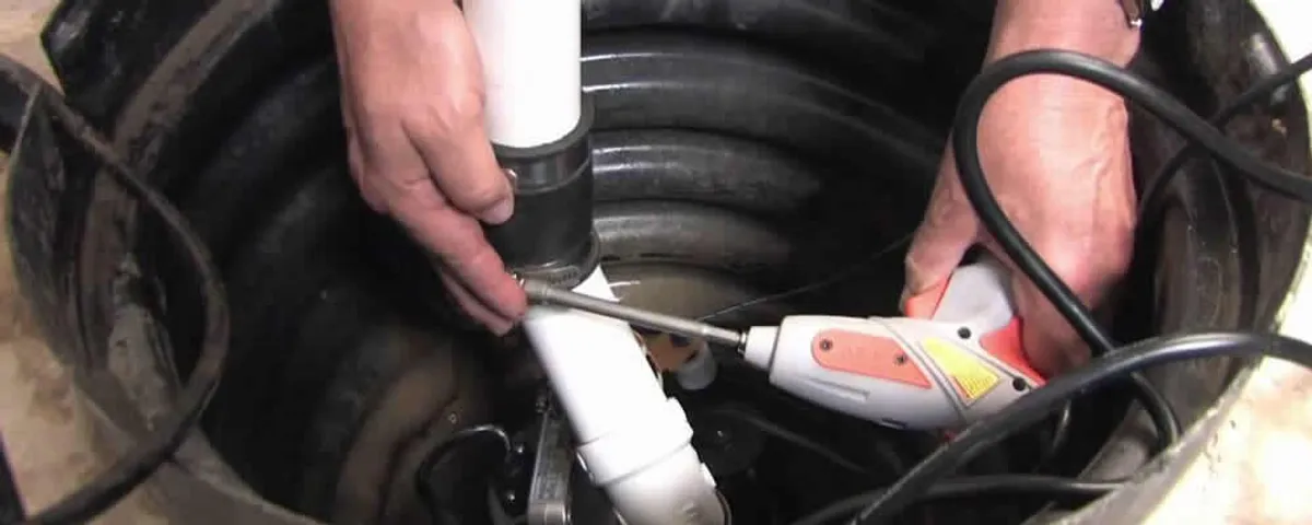 Sump pump installation technician connecting PVC discharge piping in Las Vegas, NV