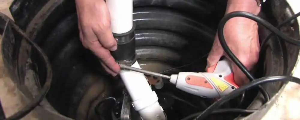 Sump pump installation technician connecting PVC discharge piping in Las Vegas, NV